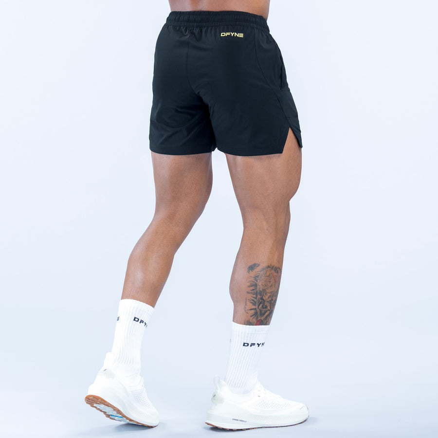 Training shorts with elastic waistband, dark fabric, rounded back hem
