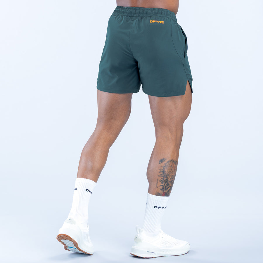 Dark green training shorts, back view with small logo and side slit details