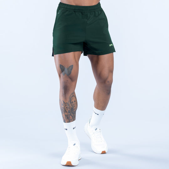 Green training shorts with elastic waistband and small logo on leg