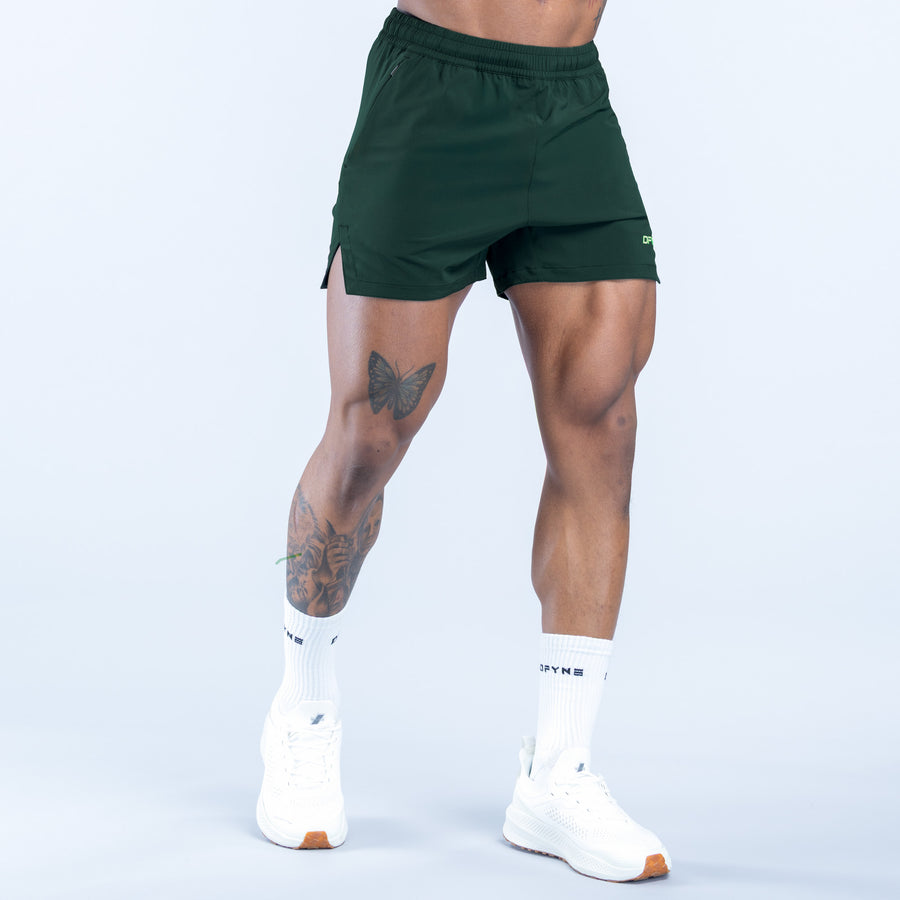 Green training shorts with adjustable drawstring waistband and logo on leg