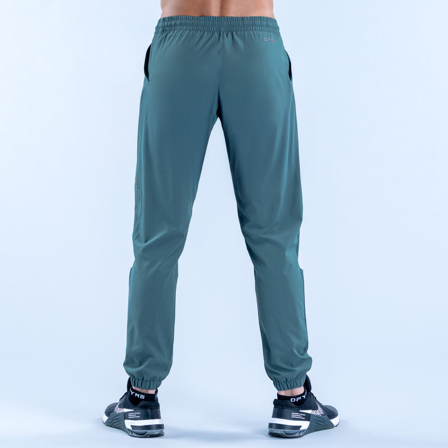 Teal training jogger pants, rear view, elastic waist and gathered ankle cuffs