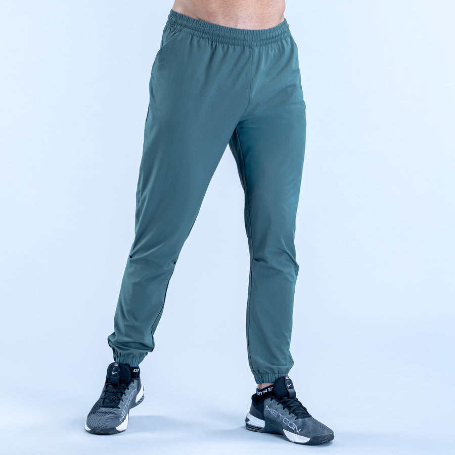 Teal training jogger pants with elastic waistband, tapered legs, and ankle cuffs
