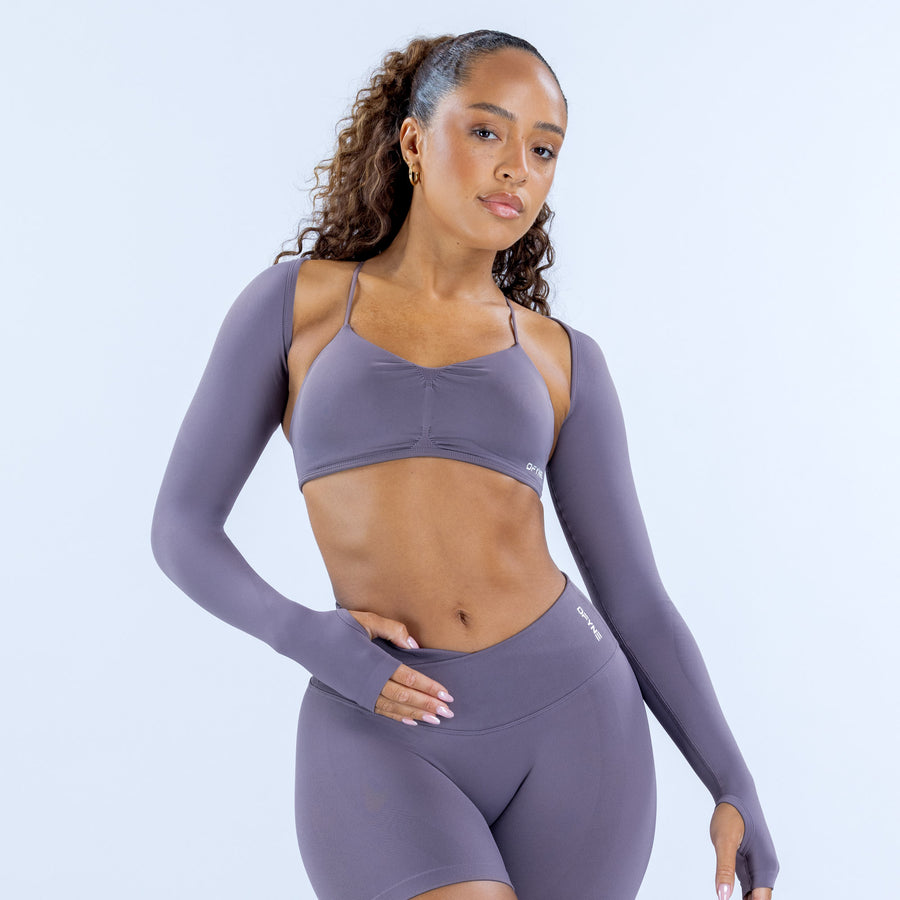 Purple long-sleeve sports shrug with open-back straps, front view