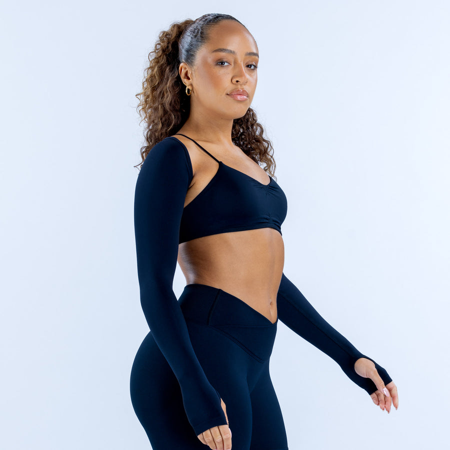 Vision shrug long dark sleeves, worn with sports bra and high-waist bottoms