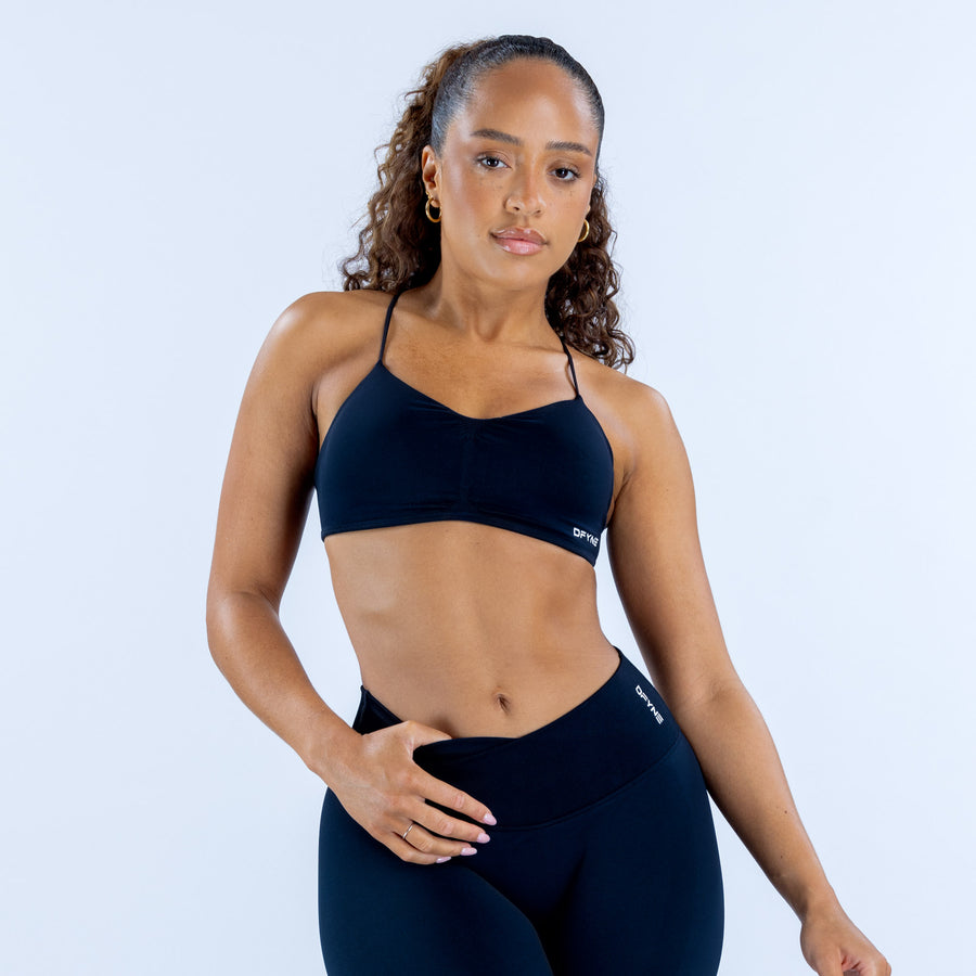 Dark navy sports bra with strappy front, fitted seamless look