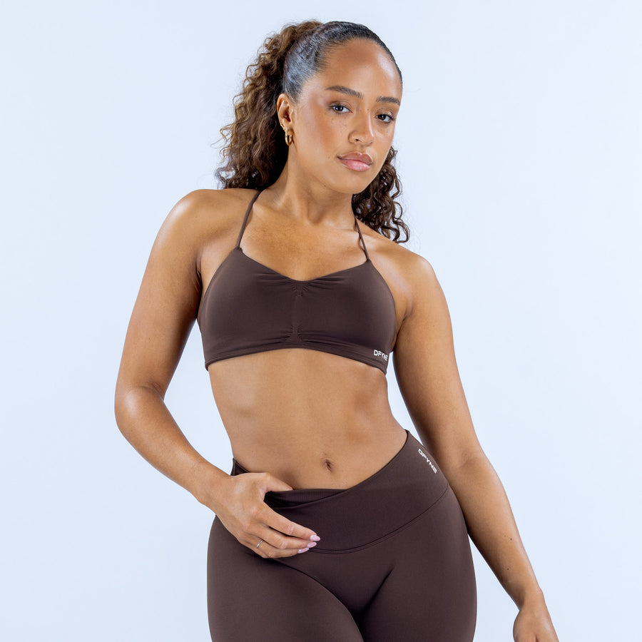 Dark brown sports bra with ruched front and DPYNE logo
