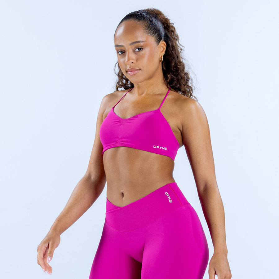 Pink strappy sports bra with thin straps and small logo