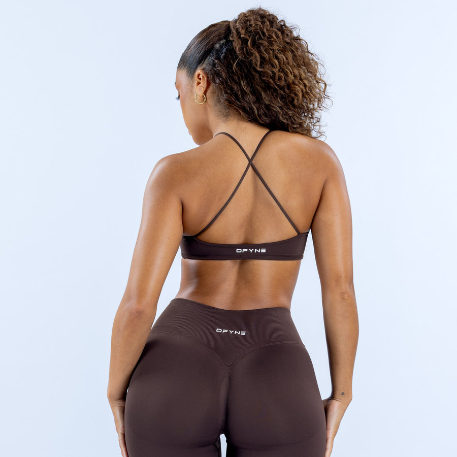 Dark brown sports bra with crisscross back straps and DPYNE logo