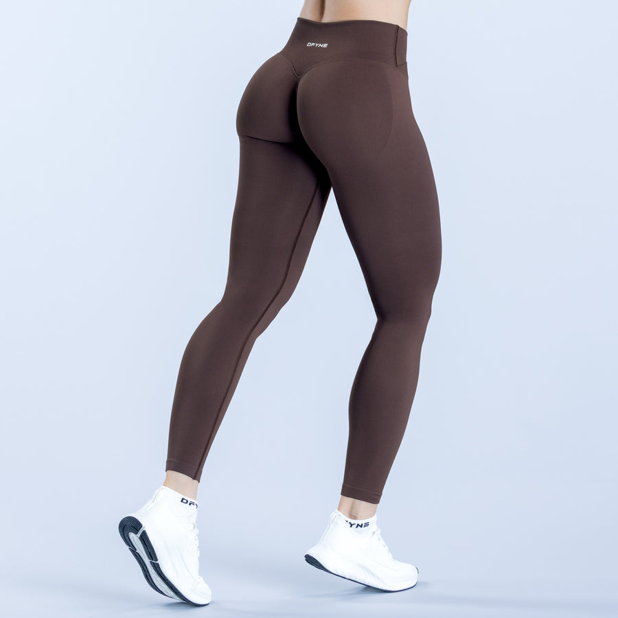 Brown high-rise compression leggings with tapered fit and small logo on waistband