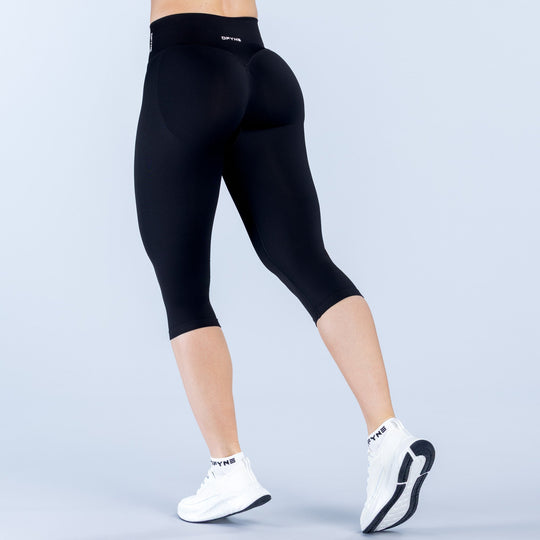 Black fitted capri leggings, straight waistband, 3/4 length, back view.