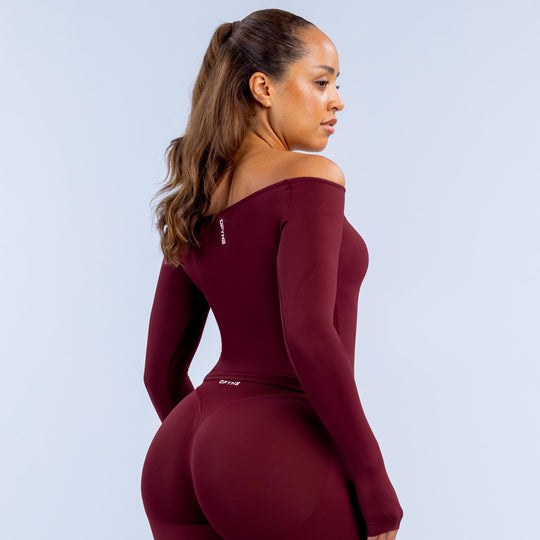 Burgundy fitted long-sleeve off-shoulder top, shown from the side with back view