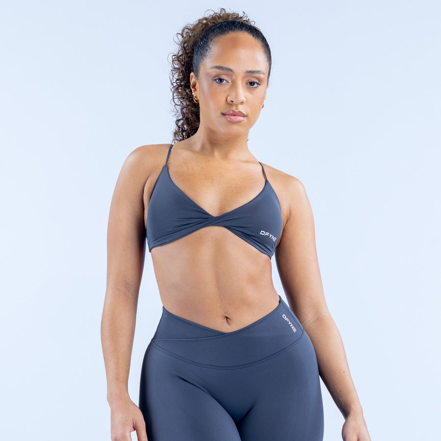 Dark navy twist-front sports bra with V neckline and adjustable thin straps