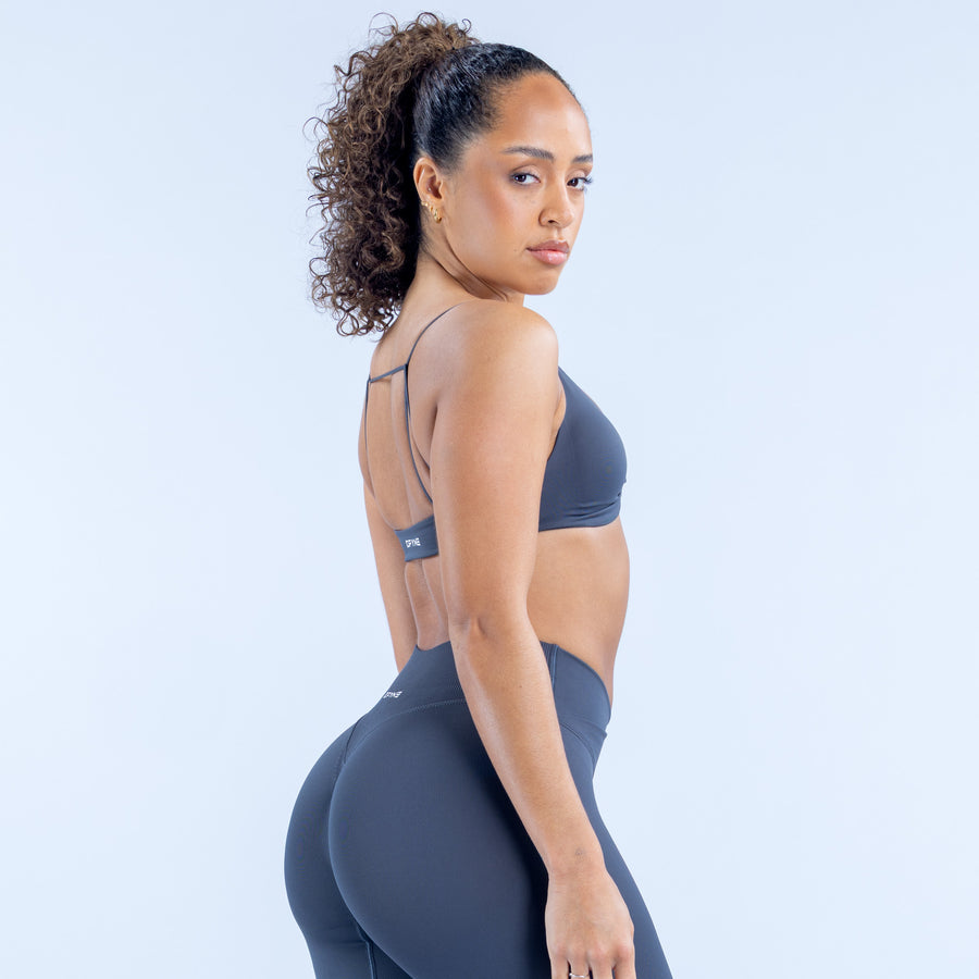 Dark navy twist-front sports bra with thin straps and racerback