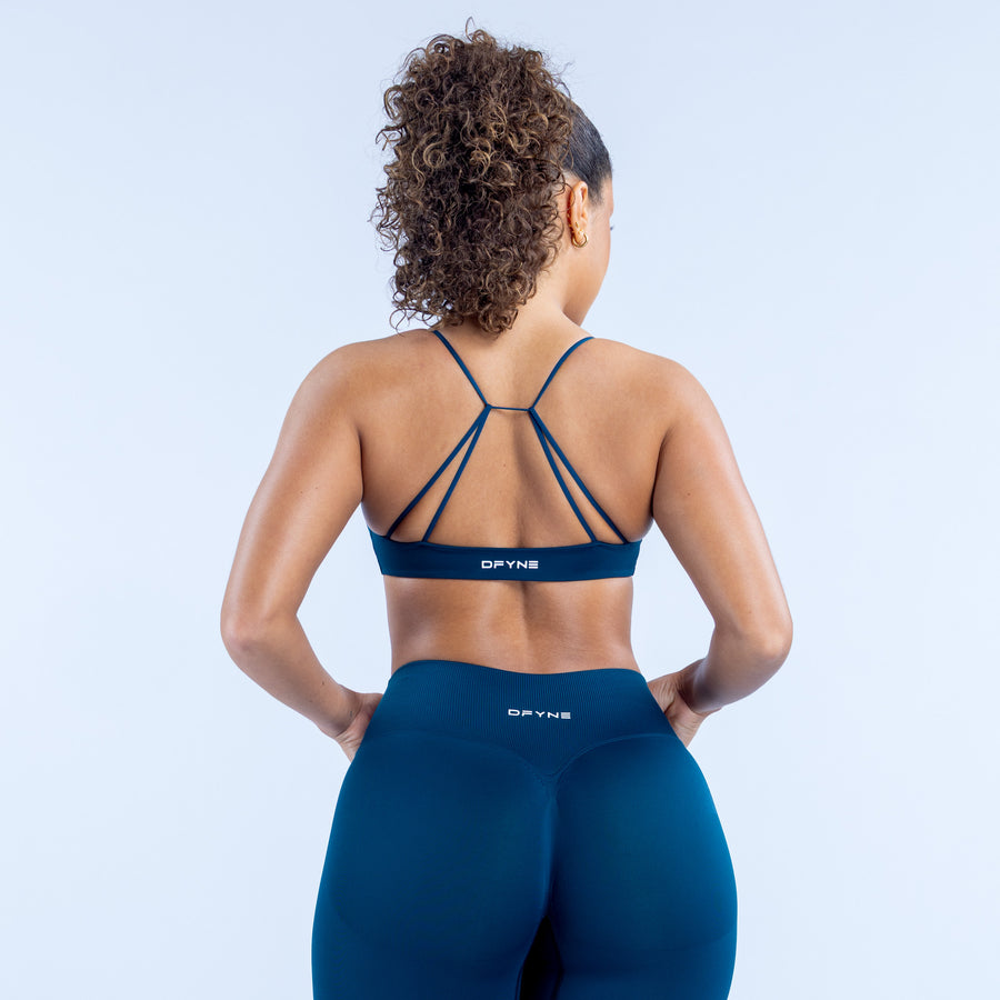 Twist-front sports bra back view with thin crisscross straps in dark blue