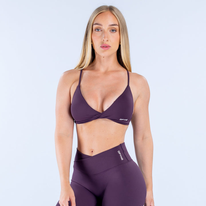 Dark purple twist-front sports bra with V neckline and elastic underband