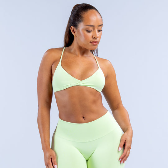 Light green V-neck twist-front sports bra with smooth stretch fabric