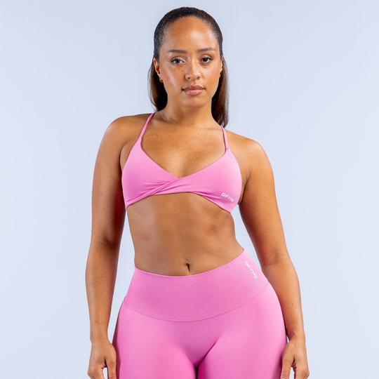 Pink twist-front sports bra with thin spaghetti straps