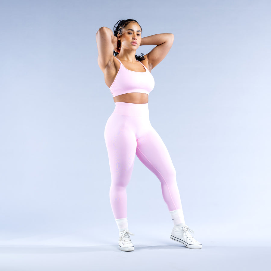 Backless sports bra with thin racer-style straps, pale pink stretch fabric
