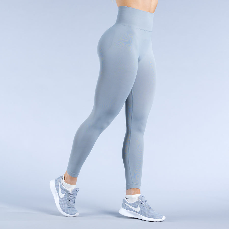Light blue performance leggings, side view with contoured seams and ankle length